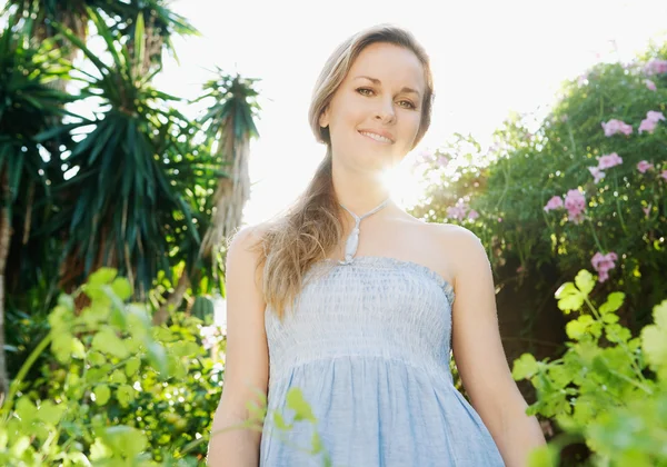 Woman standing in a green garden — Stock Photo, Image