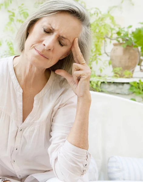 Vrouw zitten op een sofa thuis — Stockfoto