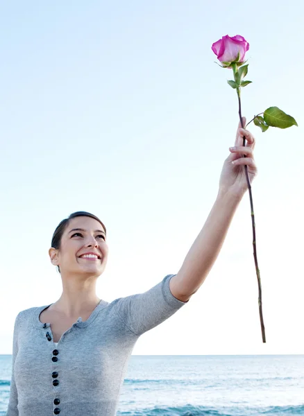 Mujer sosteniendo una rosa fresca rosa — Foto de Stock