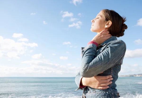 Vrouw met uitzicht op de zee en ademhaling frisse lucht — Stockfoto