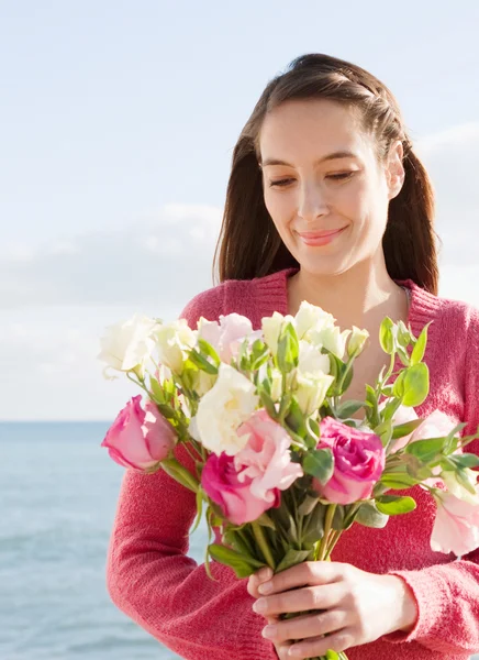 Mulher segurando um monte de flores rosa e branco brilhante — Fotografia de Stock