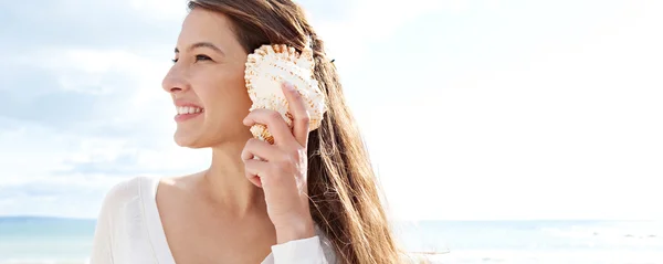 Woman holding a sea shell — Stock Photo, Image