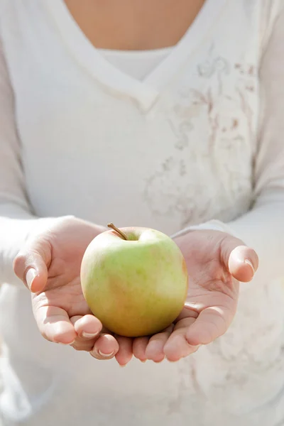 Woman hands holding an organic green apple — Stock Photo, Image