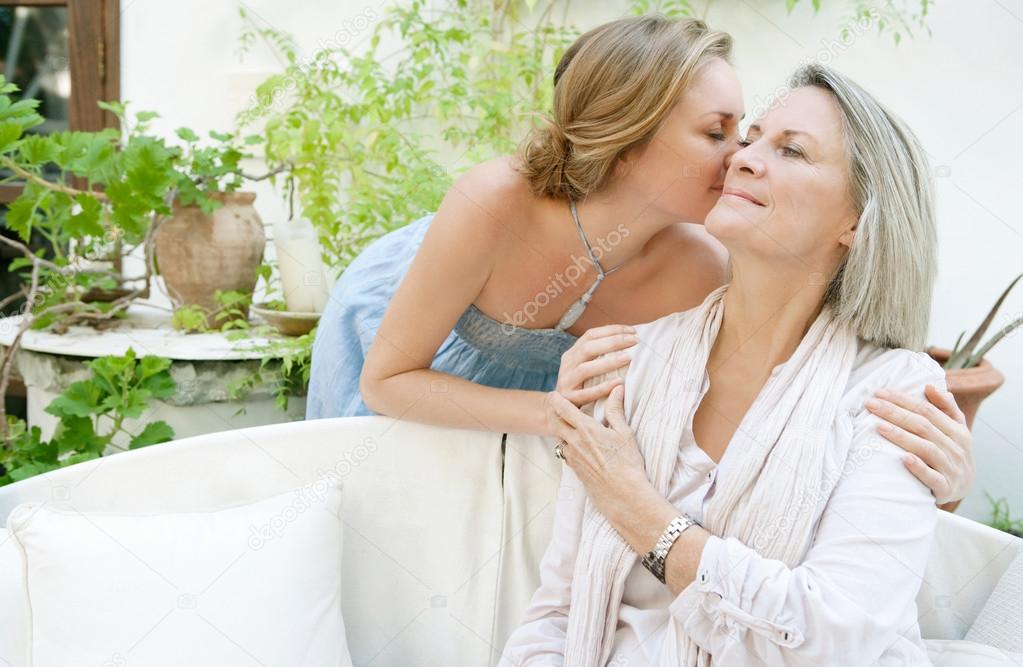 Daughter kissing her mature mother
