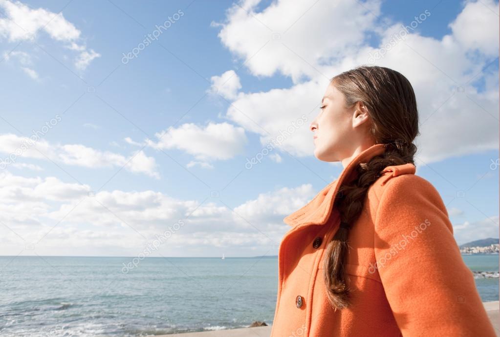Woman facing the sea and breathing fresh air