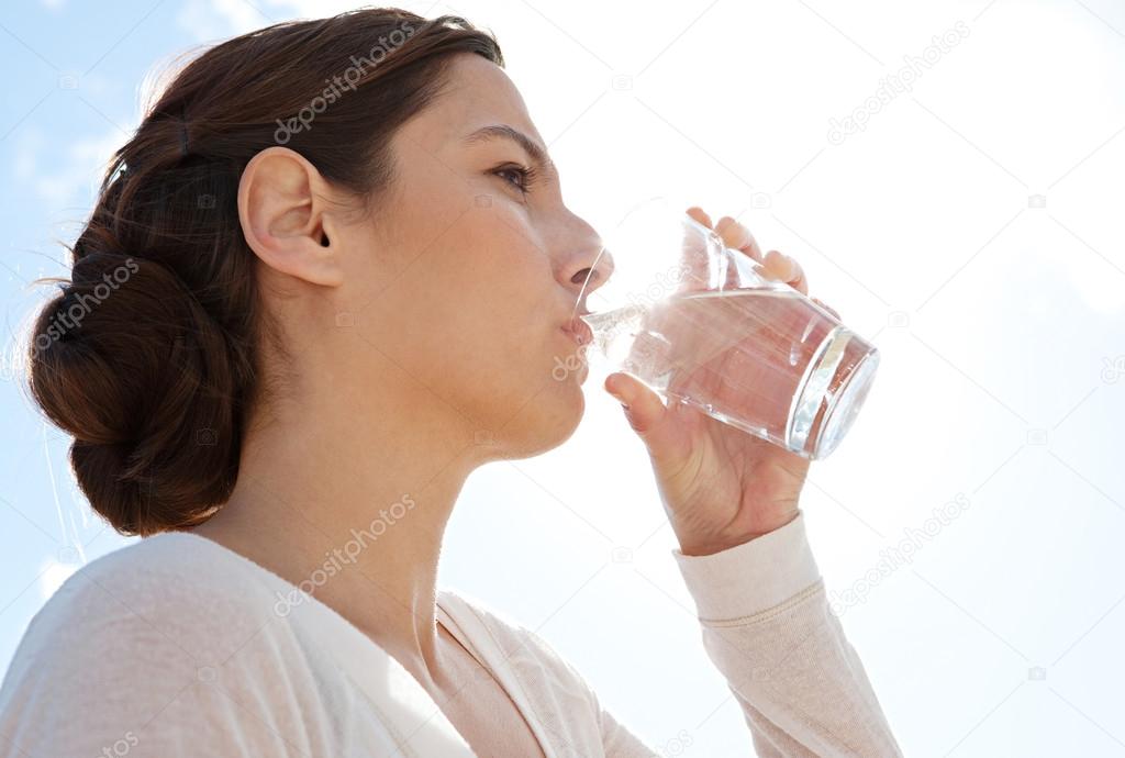 Woman holding glass of pure mineral water
