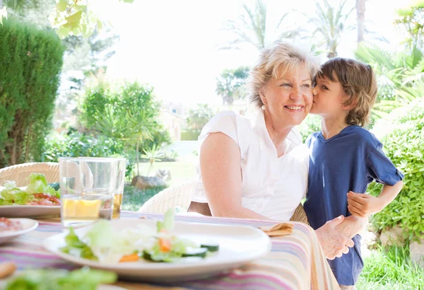 Grand child boy kissing grandmother — Stock Photo, Image