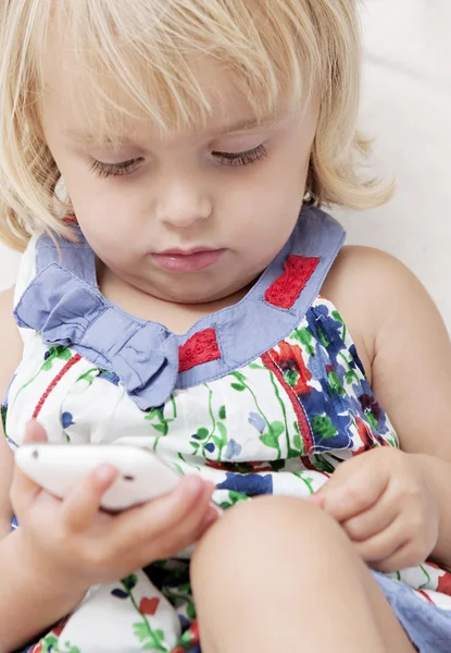 婴儿的女孩抱着一部智能手机 — 图库照片