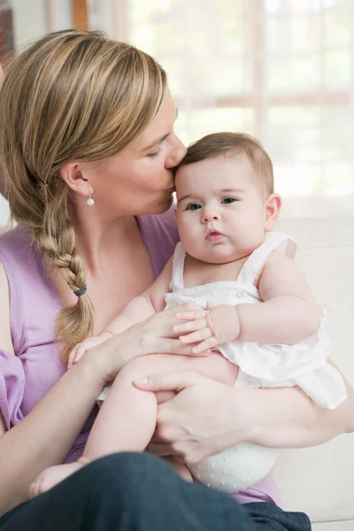 Mamma håller och kysser hennes baby girl — Stockfoto