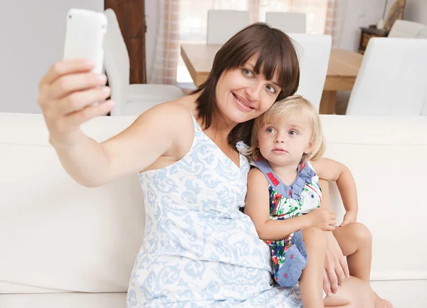 Mãe grávida e filha infantil tirar uma foto — Fotografia de Stock