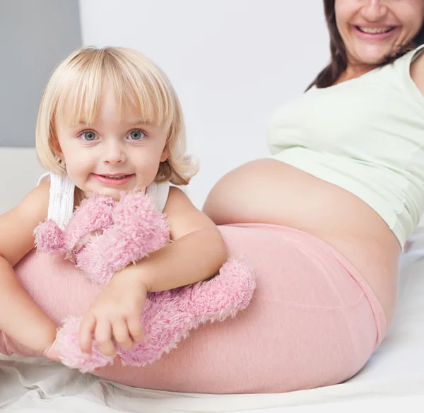 妊娠中の女性と子供の娘の演奏 — ストック写真