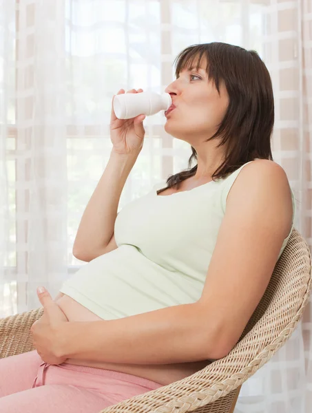 Беременная женщина пьет здоровые витамины — стоковое фото