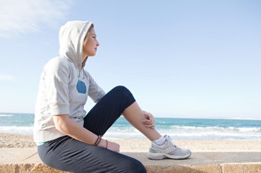 Woman sitting by a beach clipart