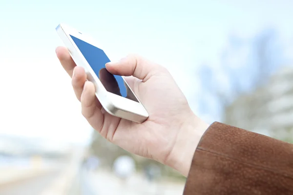 Woman's arm and hand holding a modern smart phone — Stock Photo, Image