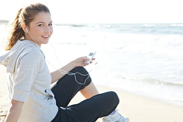 Woman sitting on a white sand beach shore — Stock Photo, Image