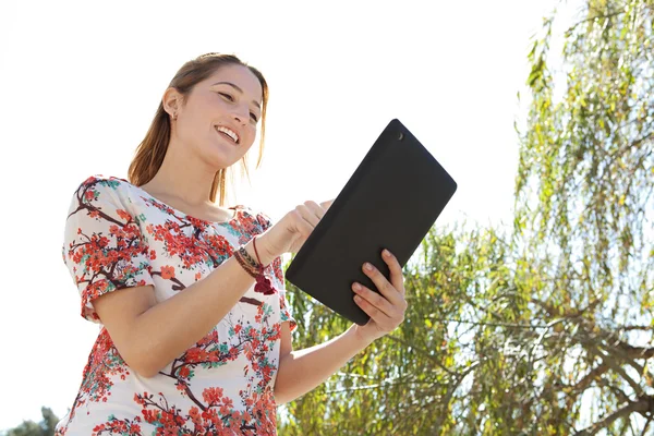 Kvinna i en park med en digital tablet — Stockfoto