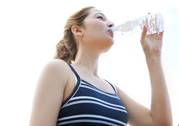 Frau setzt sich hin und trinkt Mineralwasser — Stockfoto