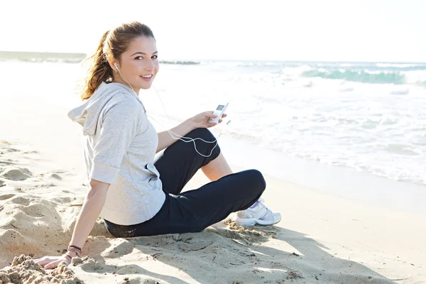 Donna seduta su una spiaggia di sabbia bianca — Foto Stock