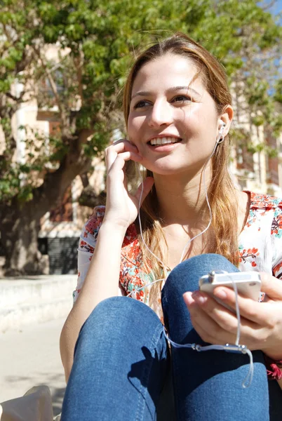 Kvinna lyssna på musik med sin smartphone — Stockfoto