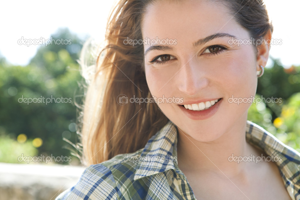 Woman smiling at the camera in a park