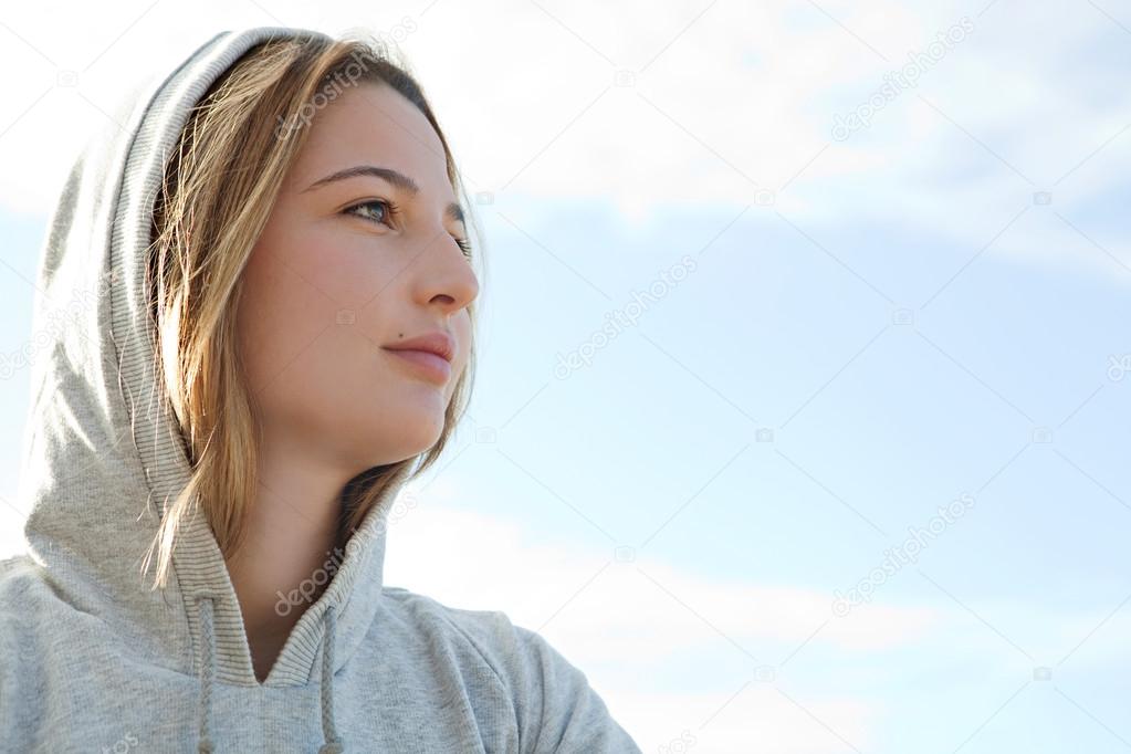 Woman wearing a hood during a sunny morning