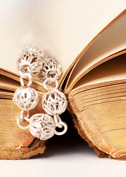 Bible book with a silver beads rosary — Stock Photo, Image