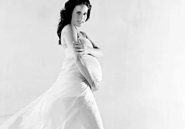 Gravid kvinna insvept i rosa silke — Stockfoto