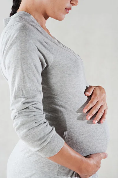 Schwangere trägt ein graues Baumwollgewand — Stockfoto