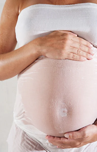 Zwangere vrouw draagt een natte katoen weefsel jurk — Stockfoto