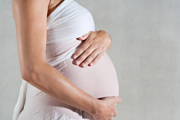 Pregnant woman holding her belly — Stock Photo, Image