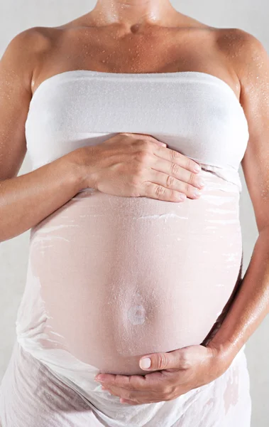 Mulher grávida usando um vestido de tecido de algodão molhado — Fotografia de Stock