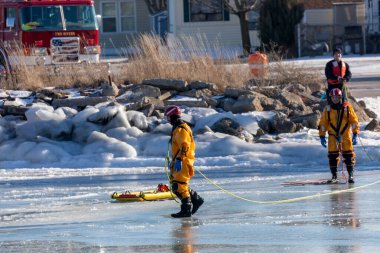 İki Nehir, WI USA 21 Ocak 2022: İtfaiye ekibi donmuş bir nehirde boğulan bir insanı kurtarma alıştırması yapıyor.