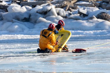 İki Nehir, WI USA 21 Ocak 2022: İtfaiye ekibi donmuş bir nehirde boğulan bir insanı kurtarma alıştırması yapıyor.