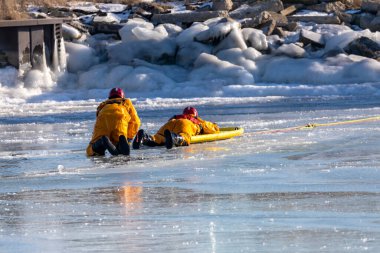 İki Nehir, WI USA 21 Ocak 2022: İtfaiye ekibi donmuş bir nehirde boğulan bir insanı kurtarma alıştırması yapıyor.