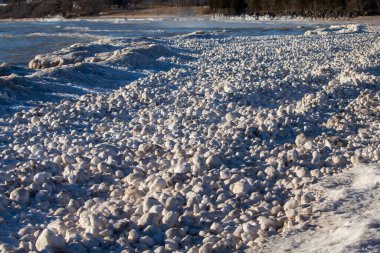 Kar, buz ve rüzgar Michigan Gölü kıyılarında düzensiz şekilli buz topları oluşturur.