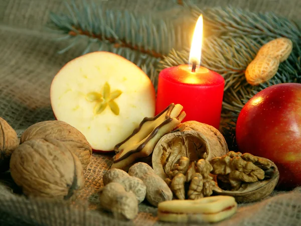 Christmas still life in red candle and dry fruit — Stock Photo, Image