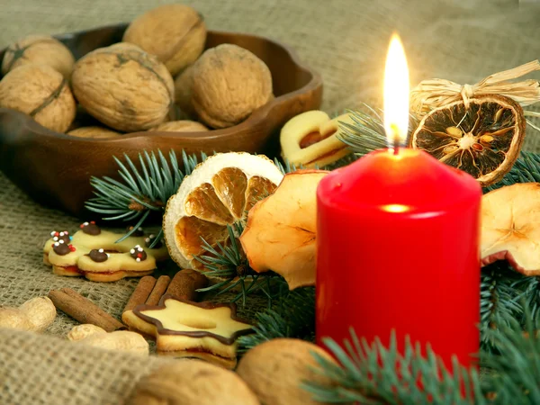 Christmas still life in red candle and dry fruit — Stock Photo, Image