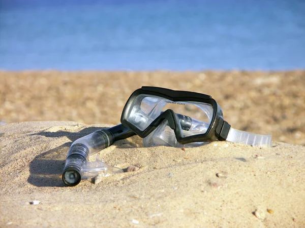 Tube and mask for a scuba diving on seacoast with sand — Stock Photo, Image