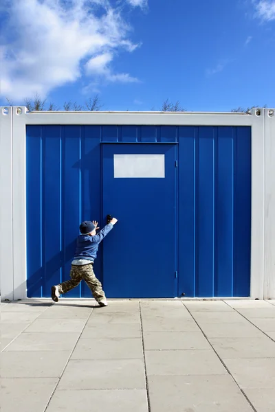 Мальчик хочет открыть дверь — стоковое фото
