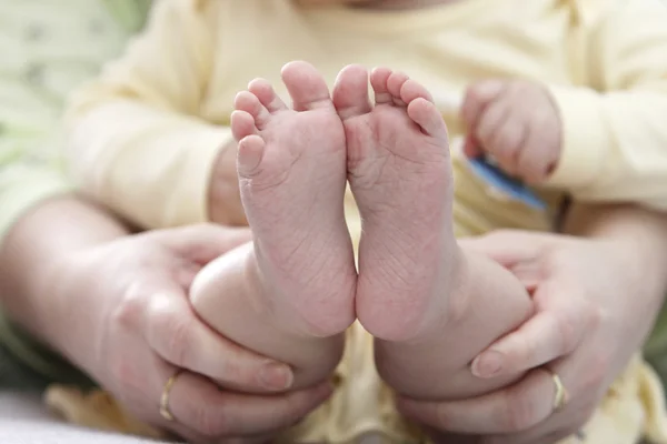 Mother holding child 's feet — стоковое фото