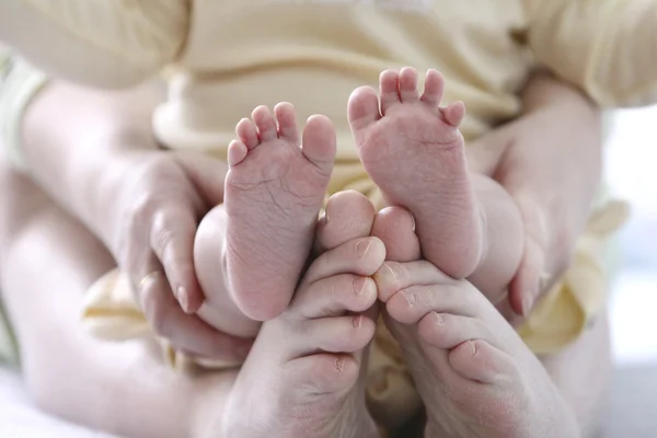 Mother holding child 's feet — стоковое фото