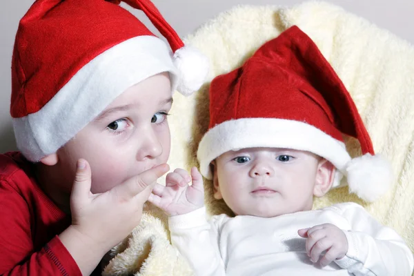 Kind en pasgeboren met kerst hoed — Stockfoto