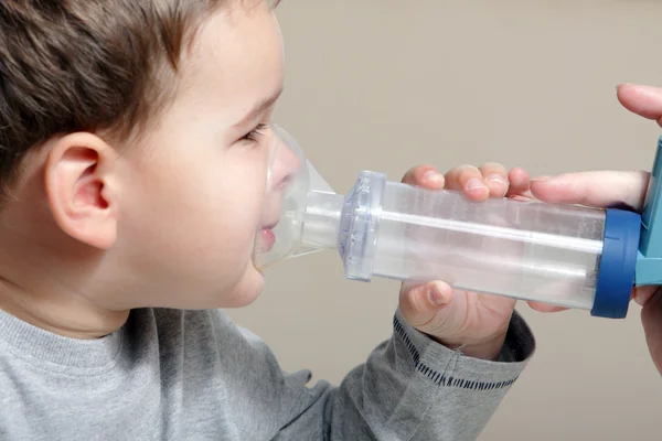 Chłopiec przy użyciu inhalatora astmy. — Zdjęcie stockowe