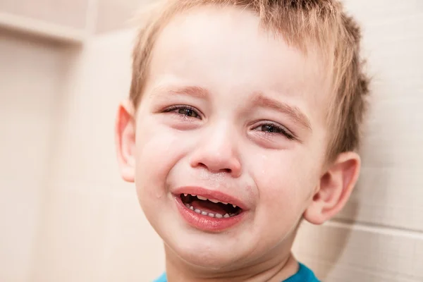 Portret van huilende baby jongen in huis. — Stockfoto
