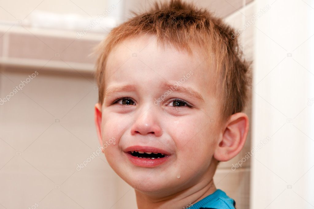Portrait Of Crying Baby Boy In Home.