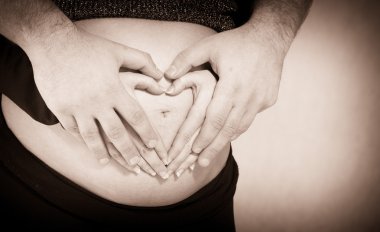 karın üzerinde kalp şekli oluşturan Çift