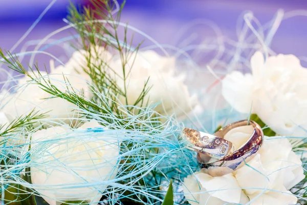 Wedding rings lying on white flower — Stock Photo, Image
