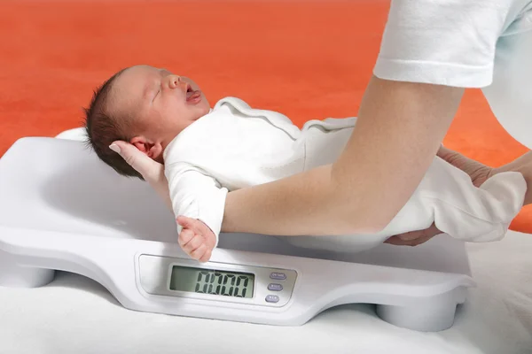 Baby boy on weight scale — Stock Photo, Image