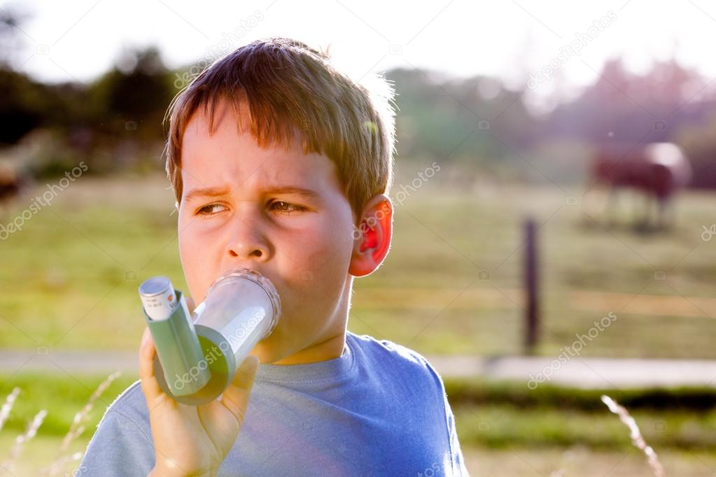 Boy using inhaler for asthma