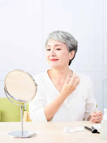 Senior Ásia Mulher Está Pulverizando Perfume Casa — Fotografia de Stock